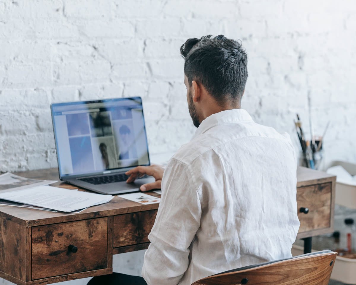 A person at work at a laptop, seen from behind
