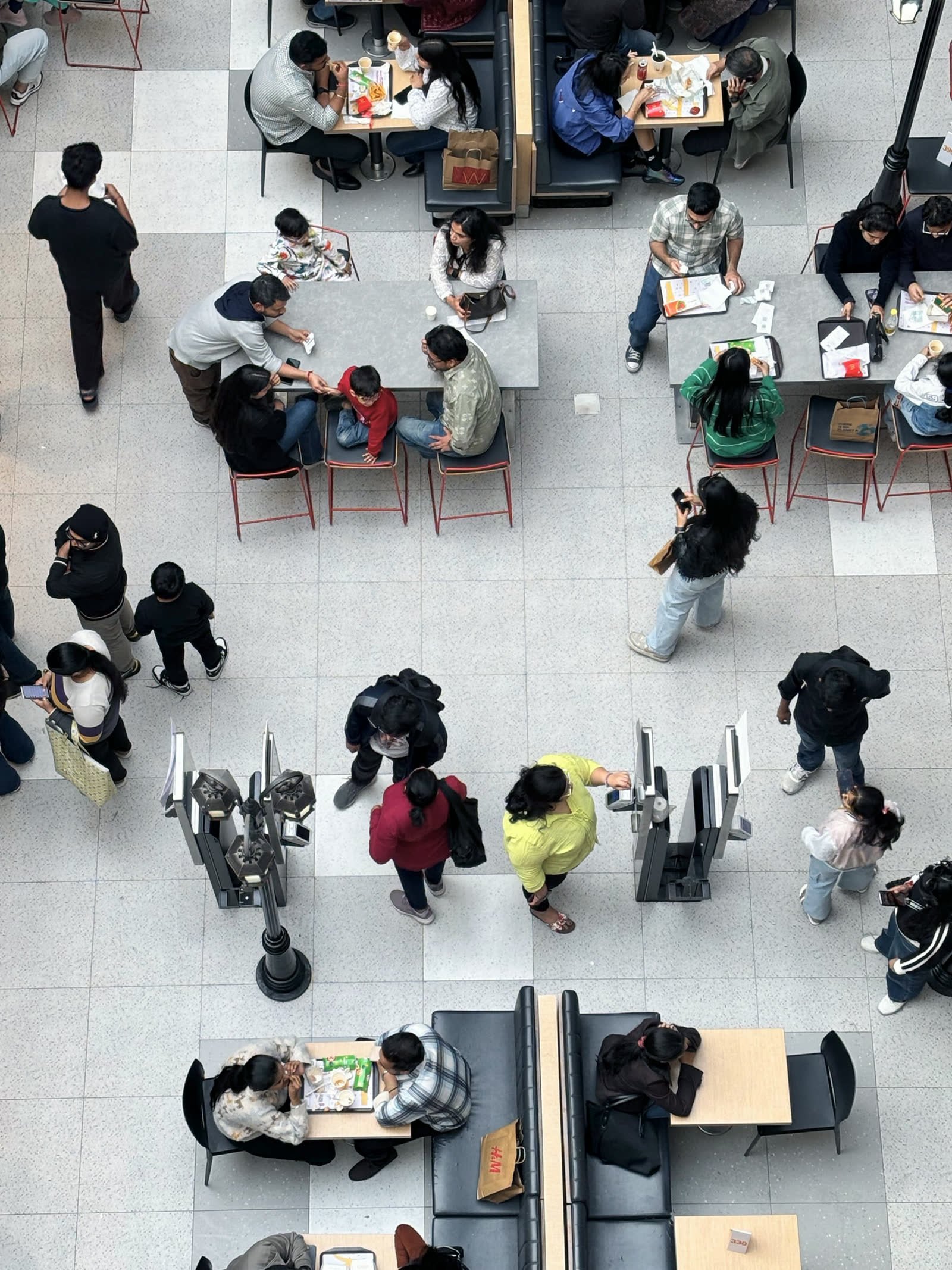 People crossing a busy hall, seen from above
